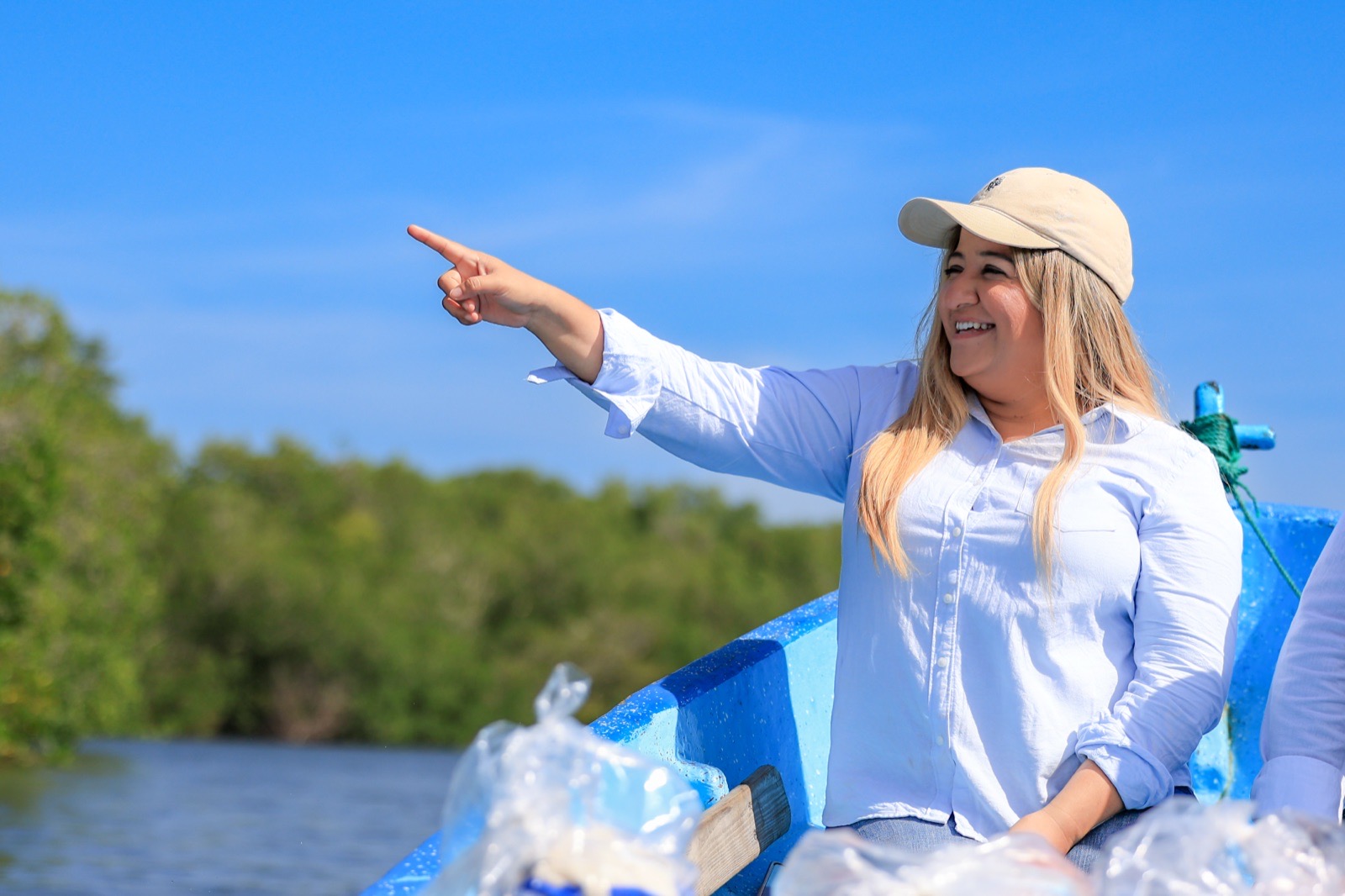 Vanessa Rivera señala el horizonte desde una lancha en el estero