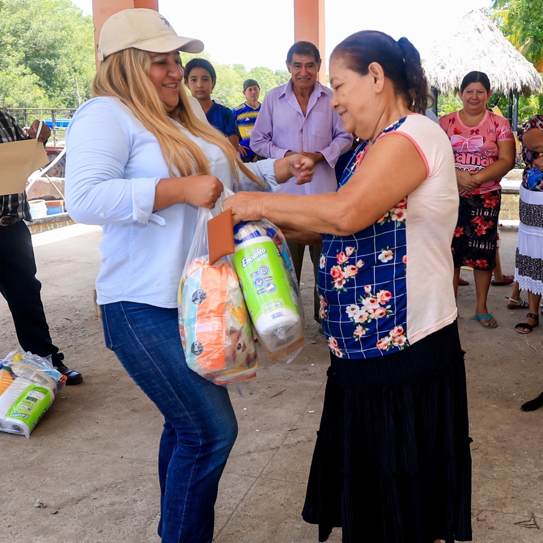 Vanessa Rivera entrega un paquete de alimentos a una vecina
